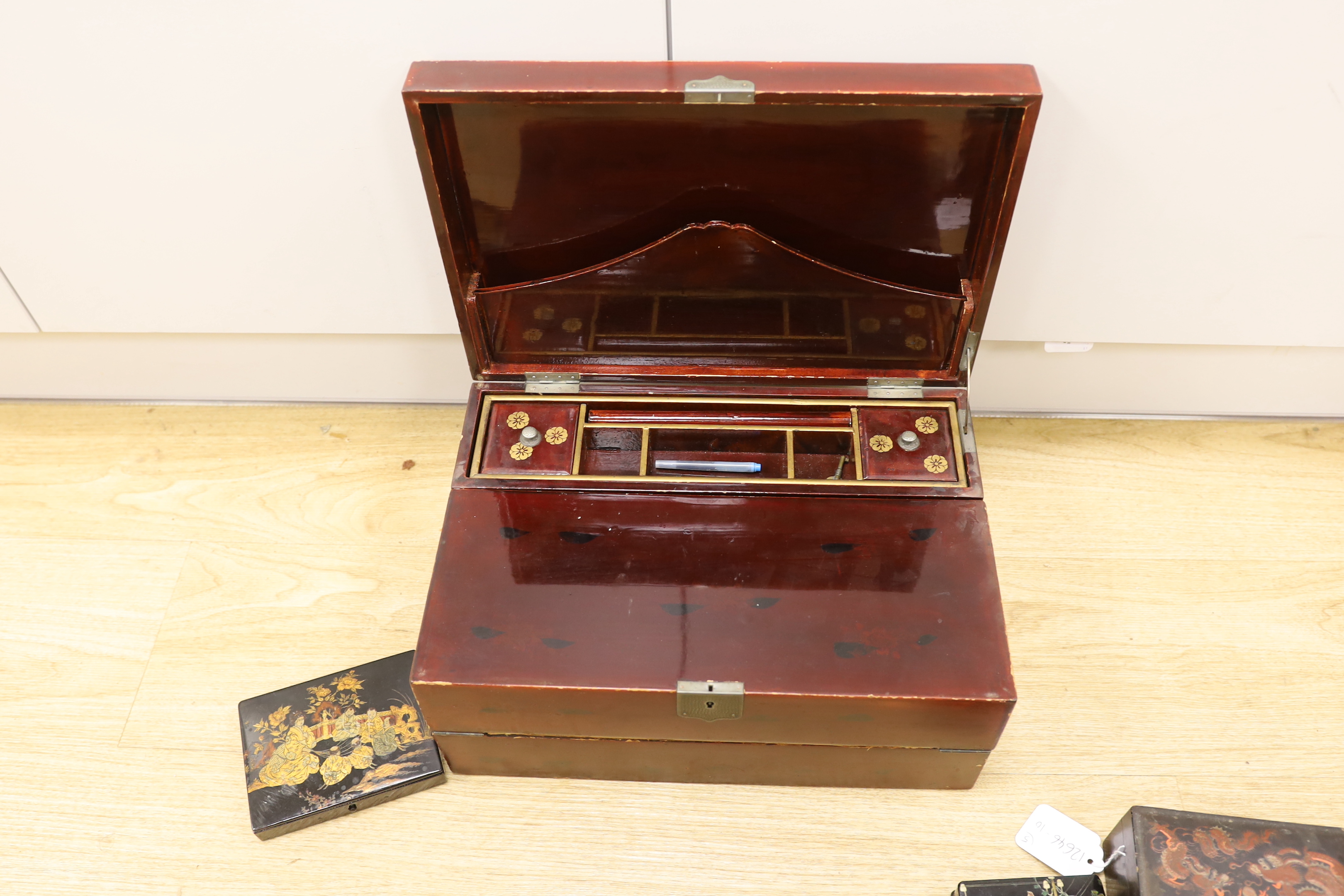 A Japanese lacquer writing box and three black lacquer or papier mache boxes